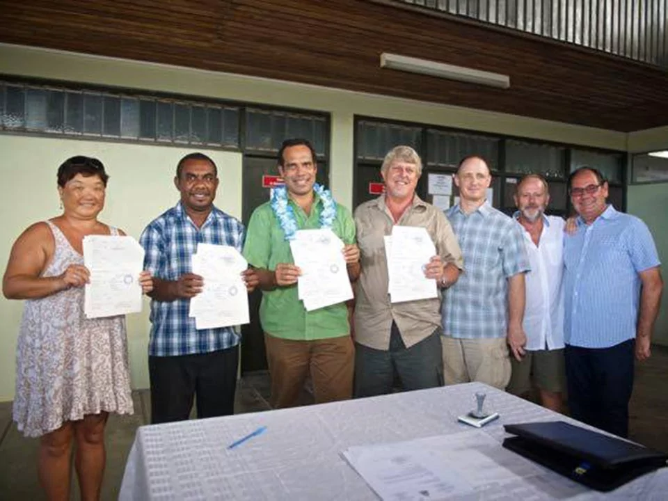 Group of people holding signed documents