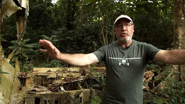 Man in jungle near plane wreckage