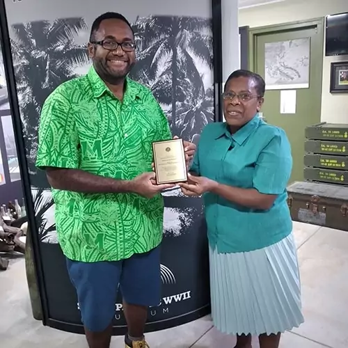 Mayor presents award to a man in a green shirt