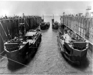 ABSD dry dock with multiple U.S. Navy landing craft, numbered 67 and 218.