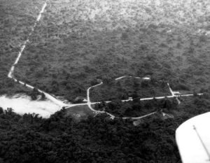 Aerial view of Aore island showing dense jungle, a road, and a clearing.