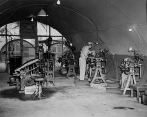 Man working at a lathe in a workshop tent at Aore.