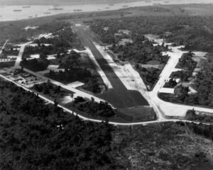 Aerial view of Santo Base airfield with runway and surrounding lush vegetation.