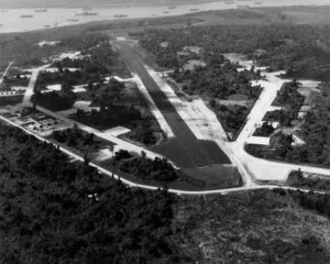 Aerial view of Santo Base airfield with runway and surrounding lush vegetation.