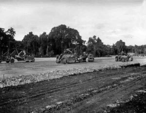 Earthmoving equipment constructs a new base in a tropical jungle setting.