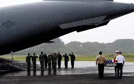 Elwood J Euart: Honor guard carries casket from military aircraft.