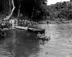Historical training: Soldiers practice water rescue with a raft and boat.