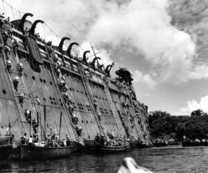 USS Coolidge sinking: survivors climb ladders to escape the listing ship.