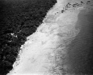 Aerial view of a beach with people and boats, historical Coolidge.