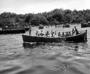 Coolidge: People in a boat on the water, with trees in the background.