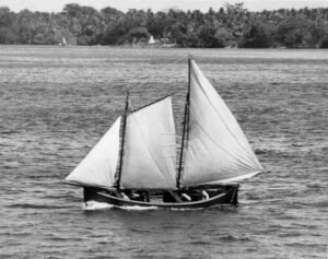 Coolidge sailboat with sails up on a body of water