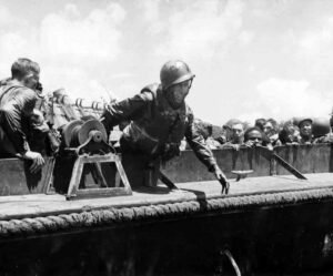 Soldier disembarking from a boat during WWII historical event.