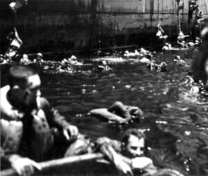 USS Coolidge survivors in water, WWII naval disaster.