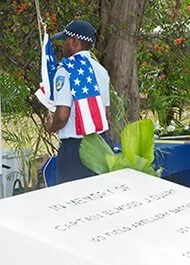 Police officer in uniform with American flag detail at a memorial service