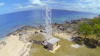 Million Dollar Point: White tower and small building on a rocky, sandy coastline.