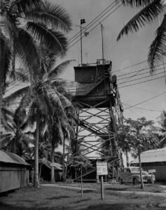 Naval air station signal tower with palm trees and a vintage car
