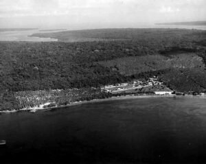 Aerial view of Santo Base with lush vegetation and calm water.