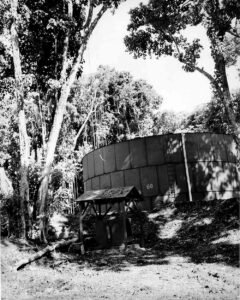 Large, weathered fuel tank numbered 60, with a small wooden shelter in foreground.