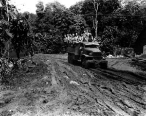 WWII truck carrying soldiers through muddy terrain