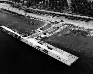 Construction of a T-shaped wharf with lumber and equipment on a tropical island.