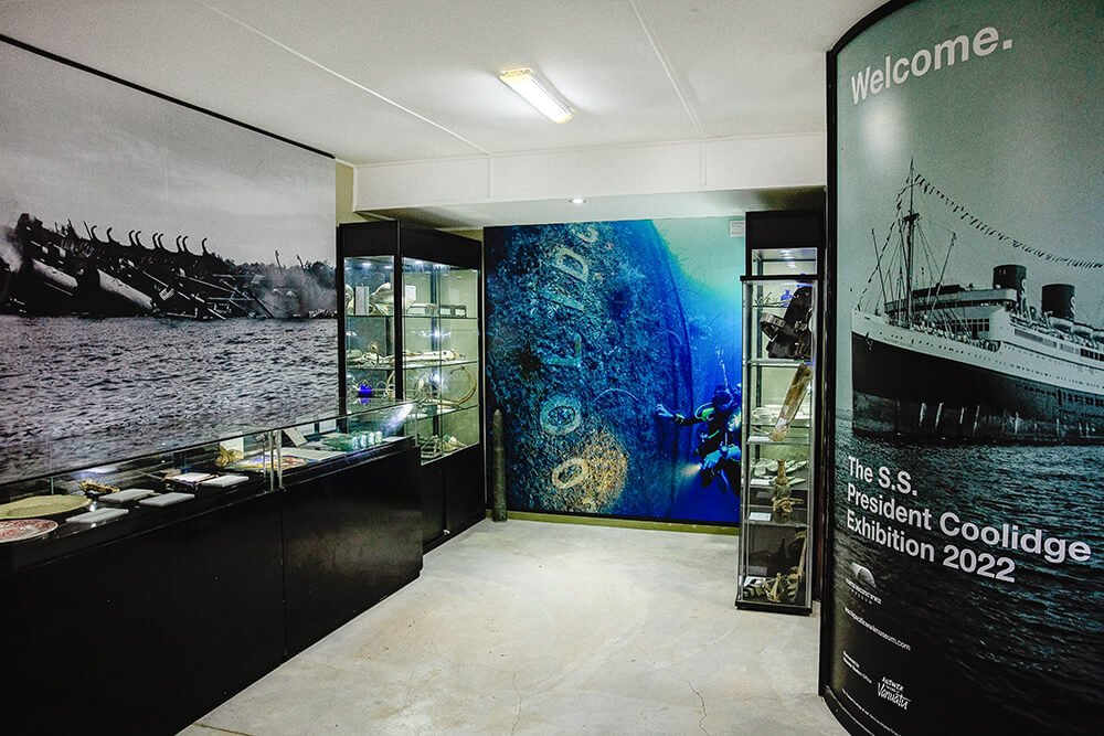 SS President Coolidge Exhibition: shipwreck artifacts, underwater diver, and ship photo