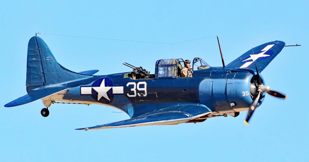 Blue Douglas SBD Dauntless dive bomber with number 39 in flight