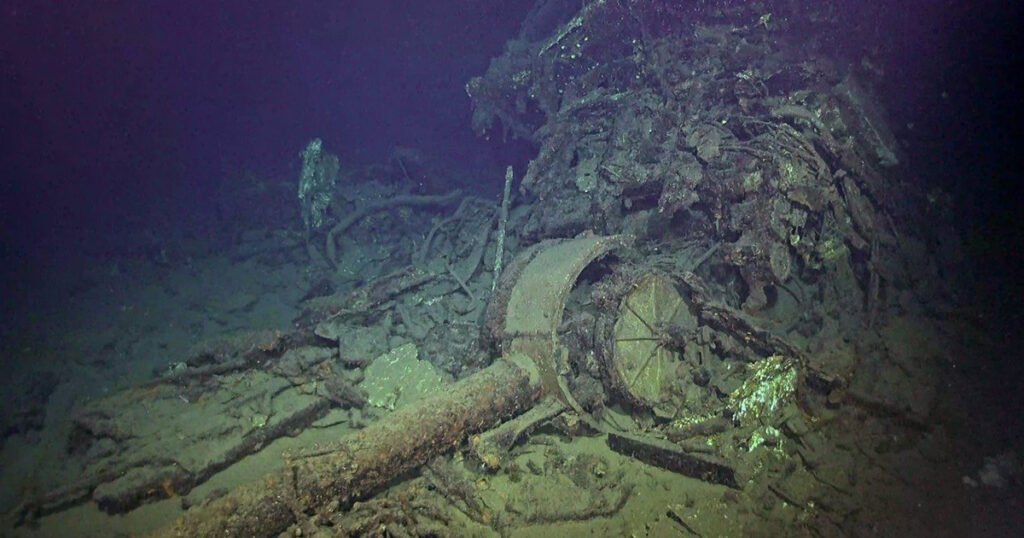 Wreckage of a ship on the seabed, showing debris and metal structures.