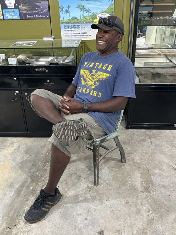 Museum team member smiling while sitting in a museum.