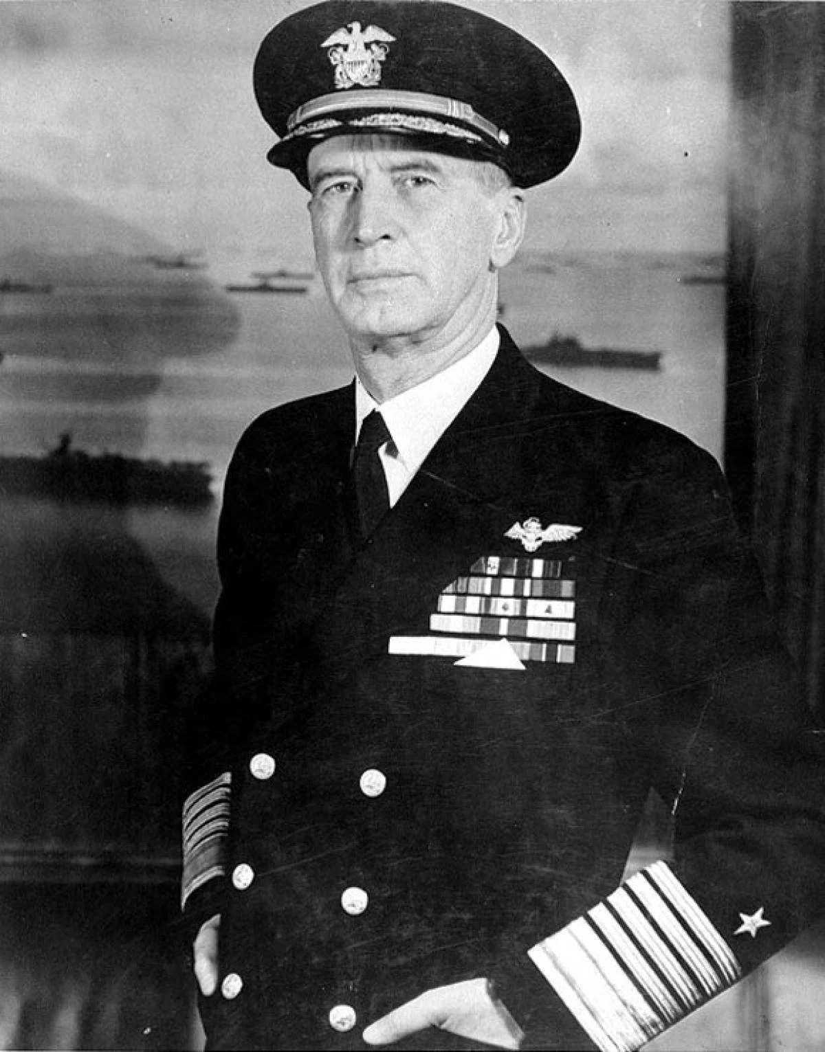 Admiral Chester Nimitz in uniform, standing before a backdrop of naval ships.