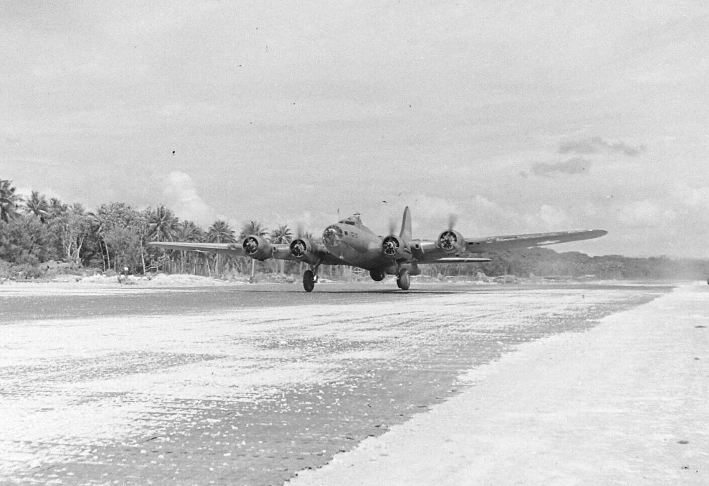 B-17 Flying Fortress bomber landing on a sandy airstrip at Santo Base