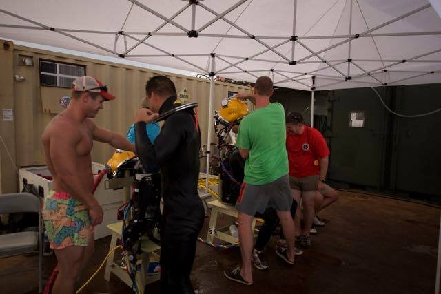 Divers preparing scuba gear under a tent for Elwood J Euart.