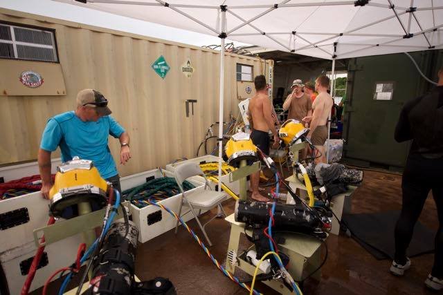Divers prepare equipment near a shipping container, Elwood J Euart