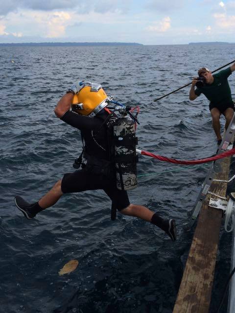 Commercial diver Elwood J Euart jumps into the ocean from a boat.