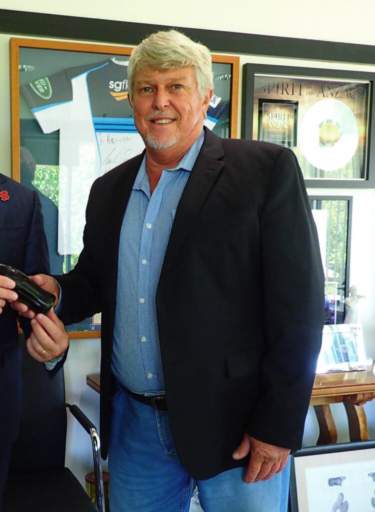 Man in a black blazer and blue shirt at a museum display