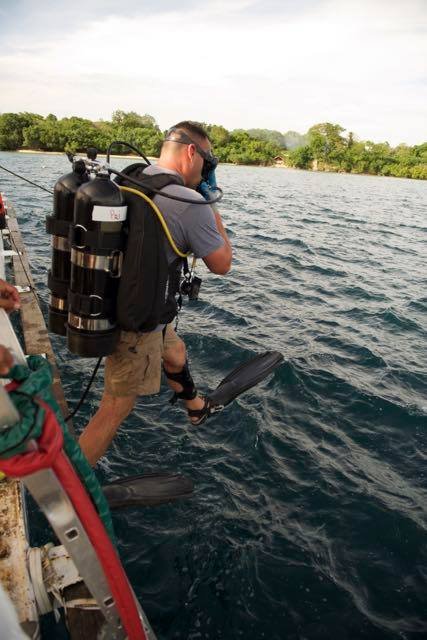 Elwood J Euart prepares to scuba dive from a boat.