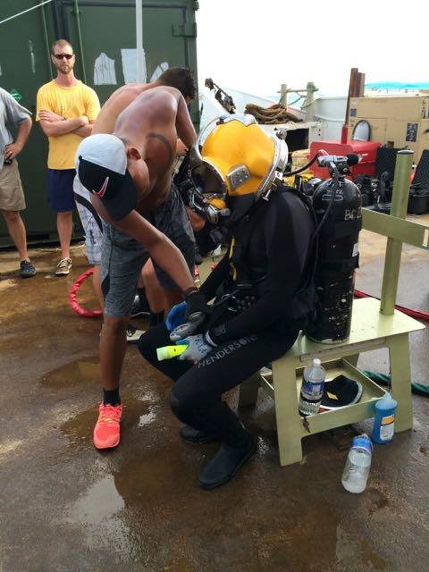 Elwood J Euart diver preparing for dive, wearing yellow helmet and black wetsuit.