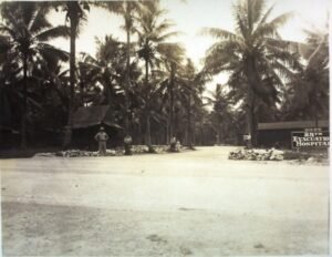 25th Evacuation Hospital entrance with palm trees and military personnel.