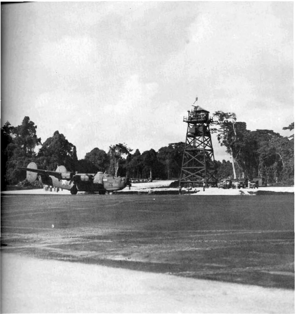 WWII bomber on a jungle airfield with a tall watchtower