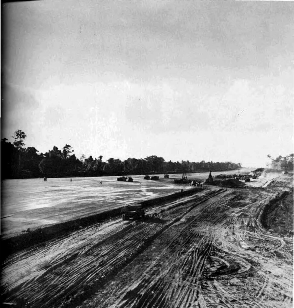 Construction of a wide airfield with heavy machinery and vehicles.