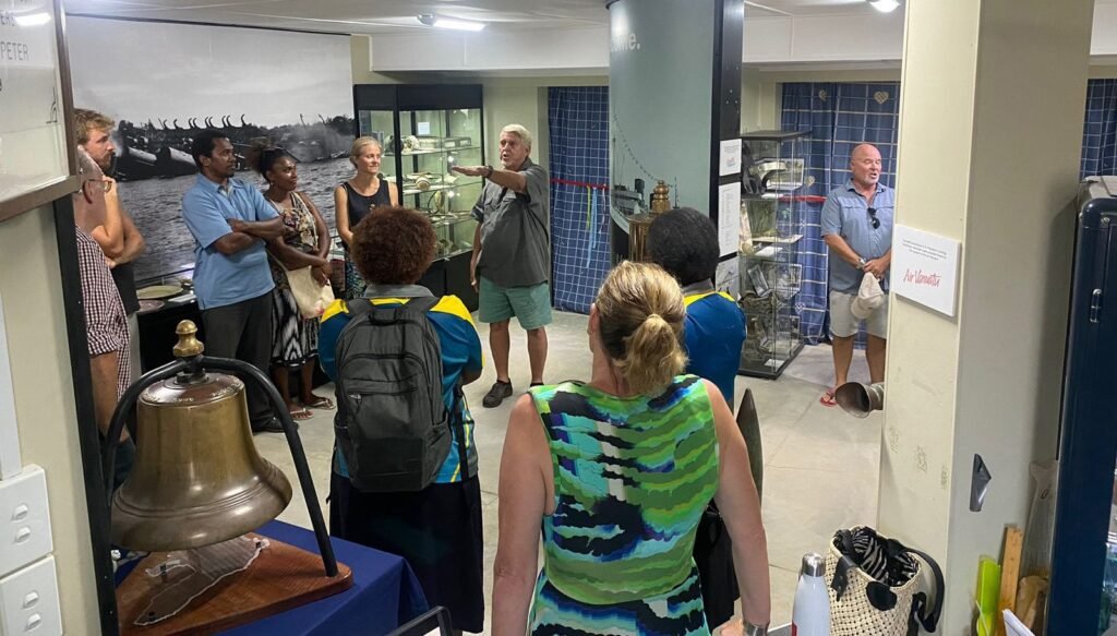 Tour group at a museum exhibit with a guide pointing