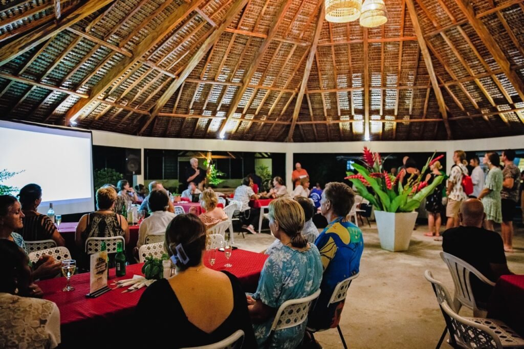 People gathered under a thatched roof pavilion for a Coolidge Commemoration event.