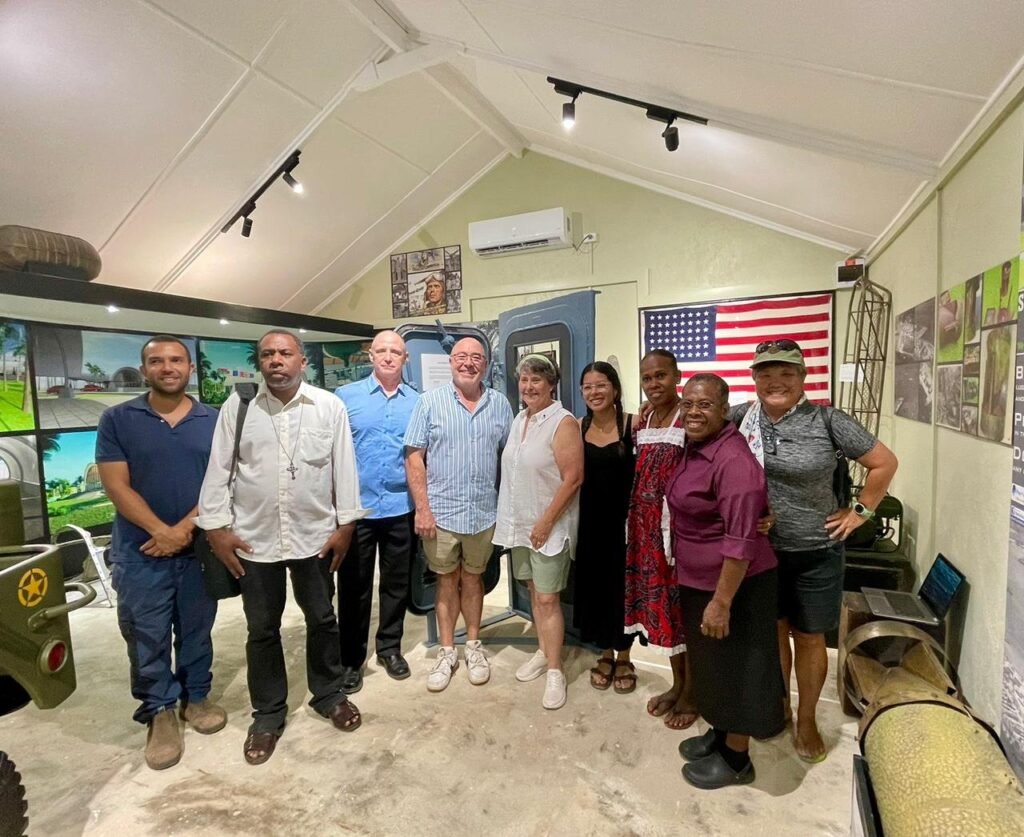 Group of people posing in a museum exhibit with an American flag