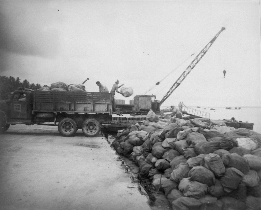 Million Dollar Point: Crane loads sacks onto truck from a pier.