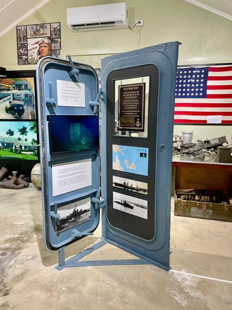 Naval display featuring a ship's door with historical photos and artifacts.