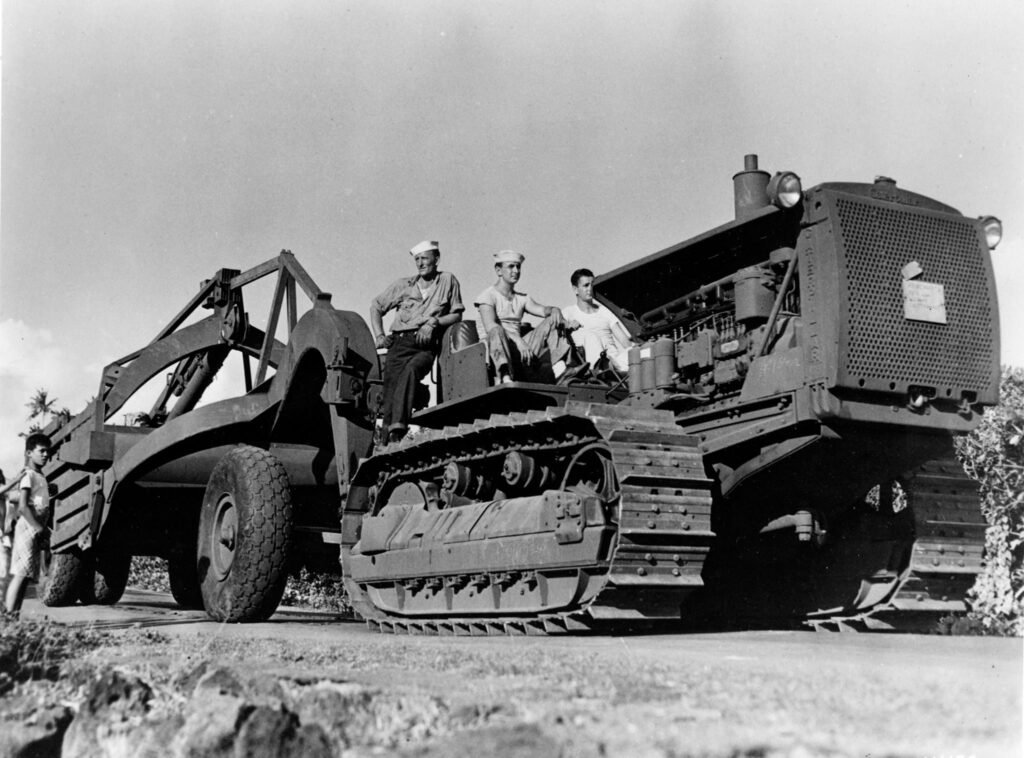 Men in uniform on a large construction tractor at Million Dollar Point.