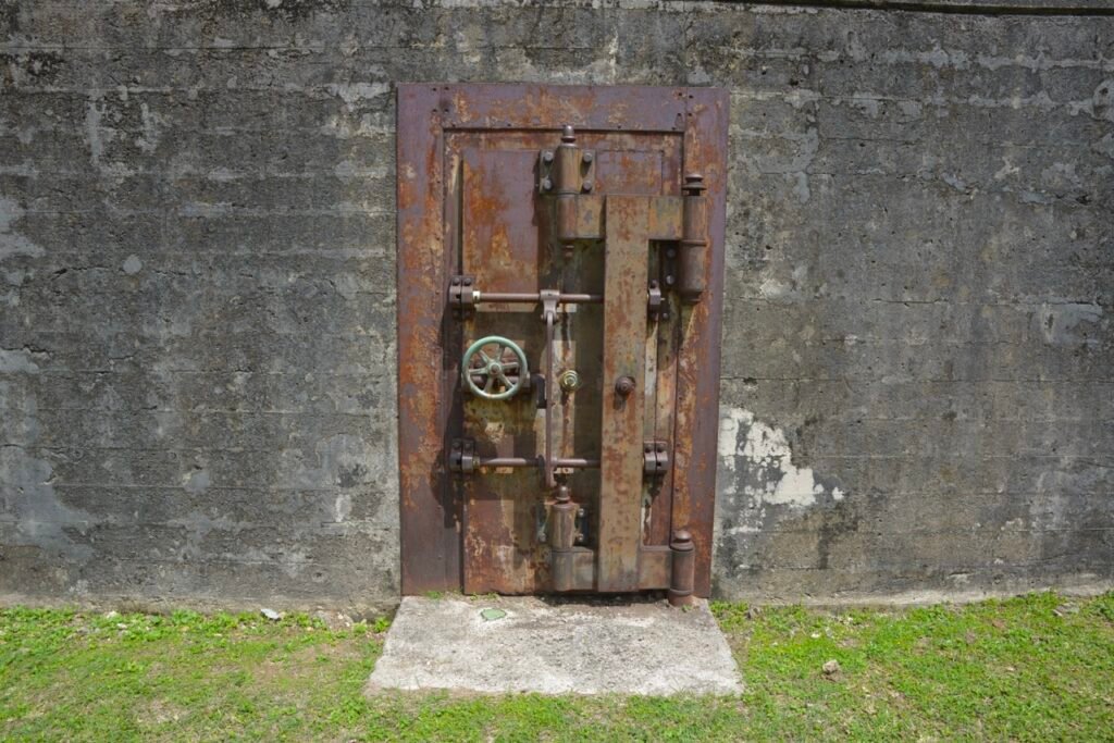 Rusted vault door set in a concrete wall, part of The Vault blog.