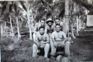 Five shirtless soldiers in a tropical setting, possibly from the 25th Infantry Division.
