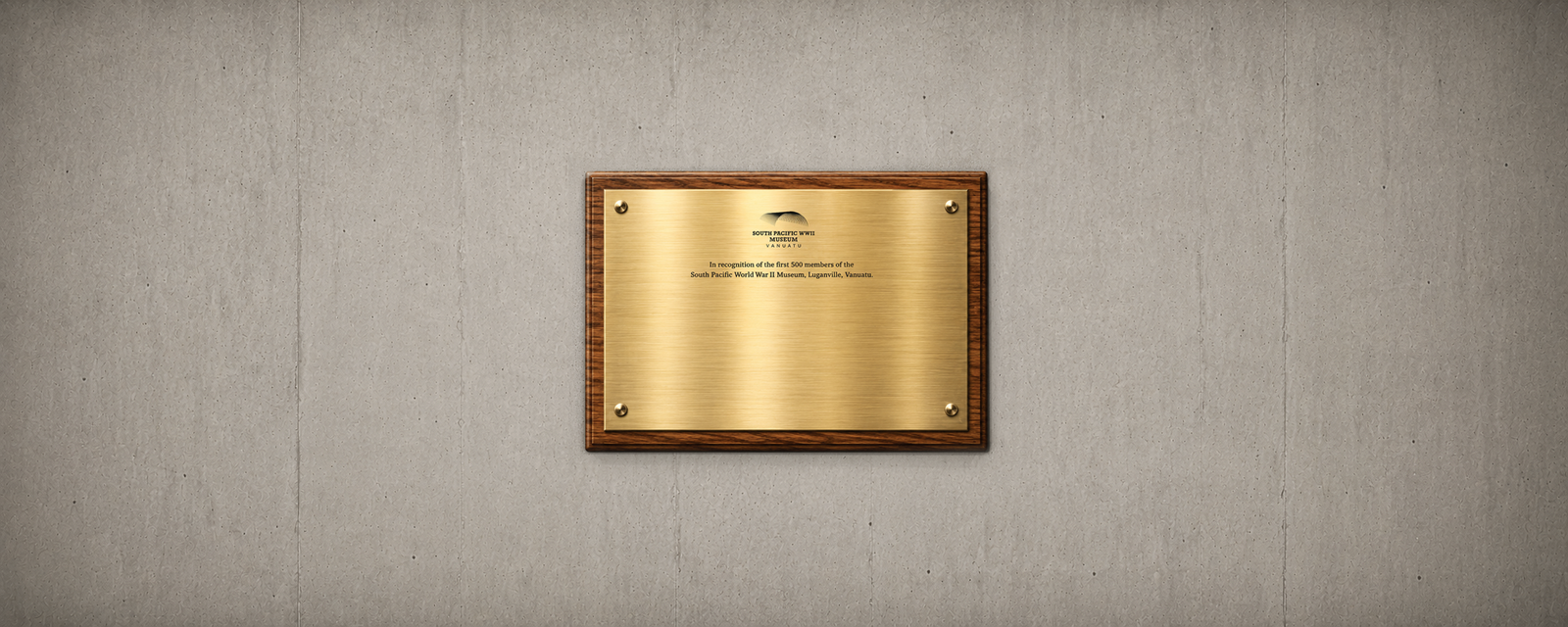 Brass plaque on a concrete wall: "WEST PACIFIC WWII MUSEUM" and dedication text.