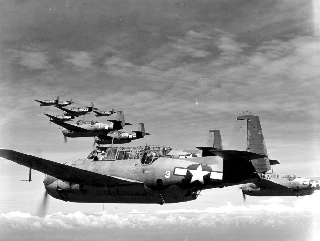 Grumman TBF Avenger torpedo bombers flying in formation over clouds